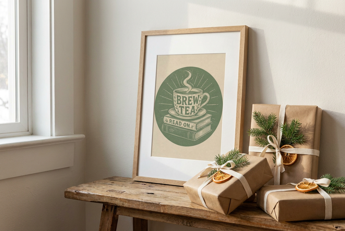 Framed tea and books linocut leaning on a wooden bench beside kraft-wrapped gifts with spruce sprigs